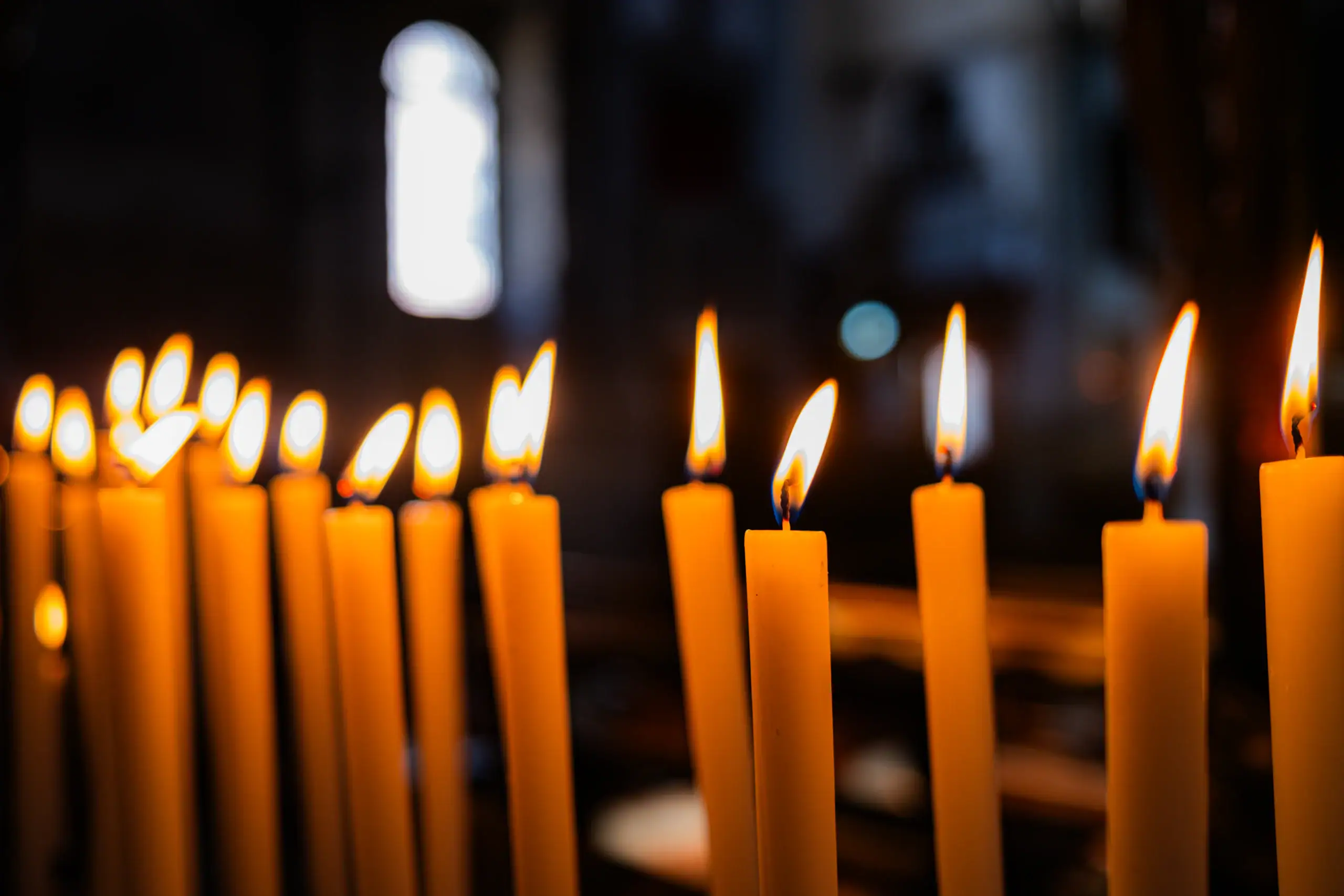 Lit candles softly glow in the dark, reflecting the peaceful mood of Islamic Funeral Services New York.